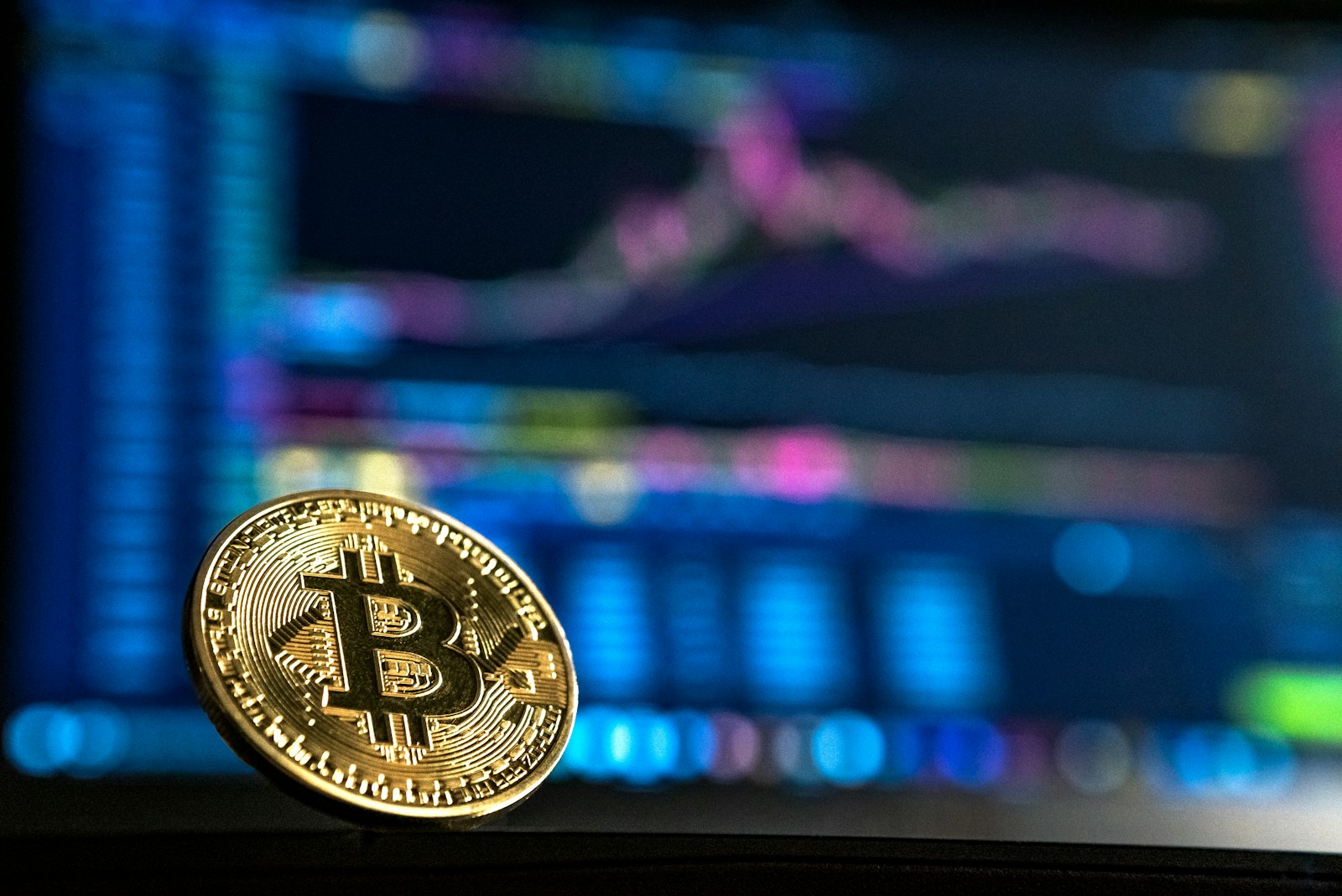 Fyysinen bitcoin-kolikko mustalla taustalla